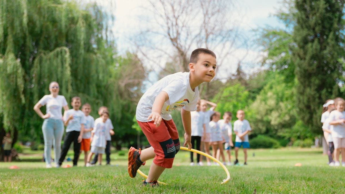 Kids enjoy outdoor fun with hula hoops in a vibrant park setting.